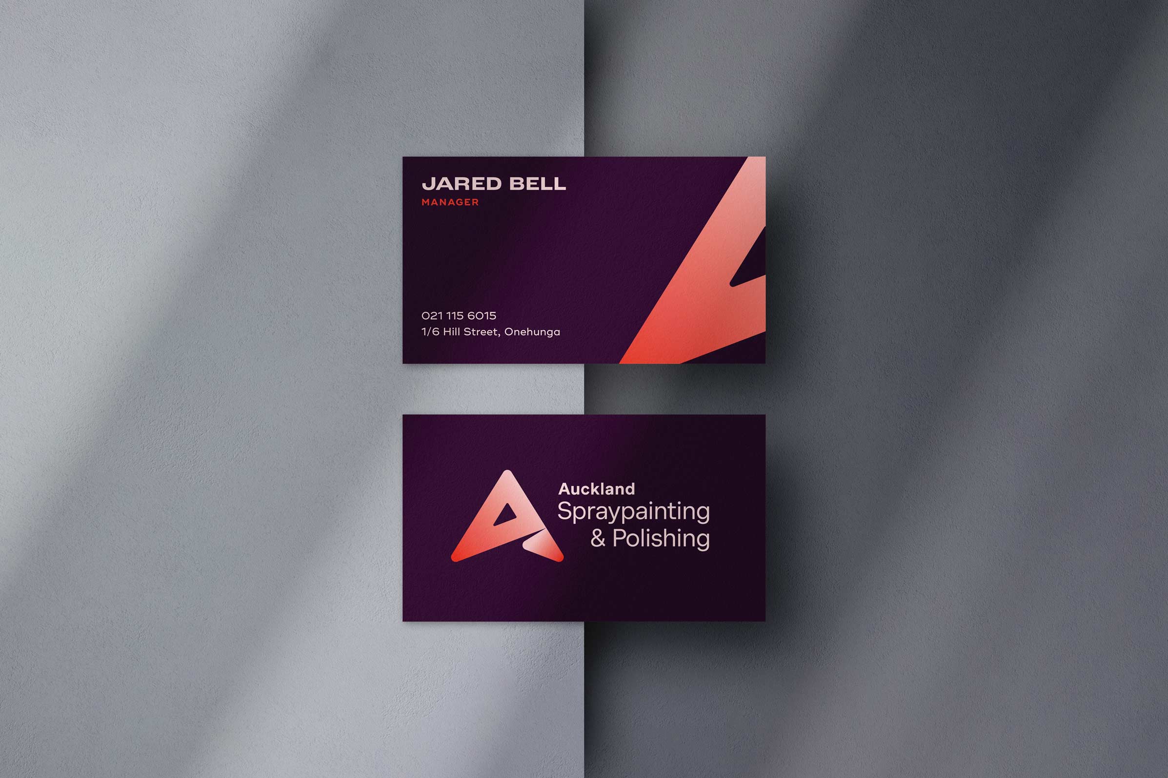 Business card showcasing a unique gradient logo design on a grey background