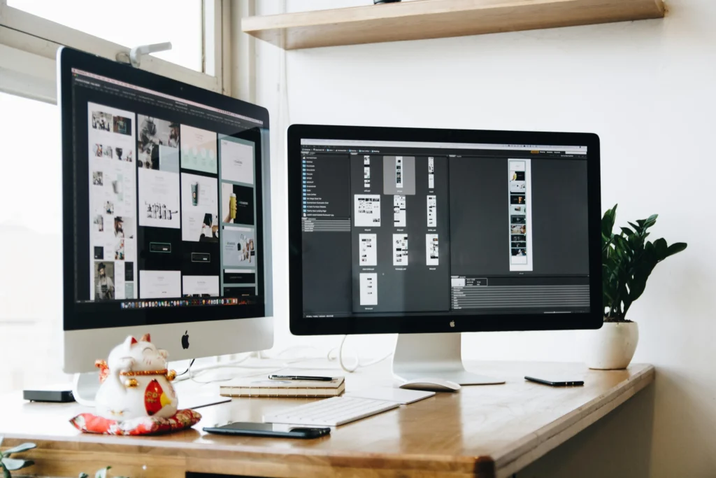 Graphic design work open on two monitors in office