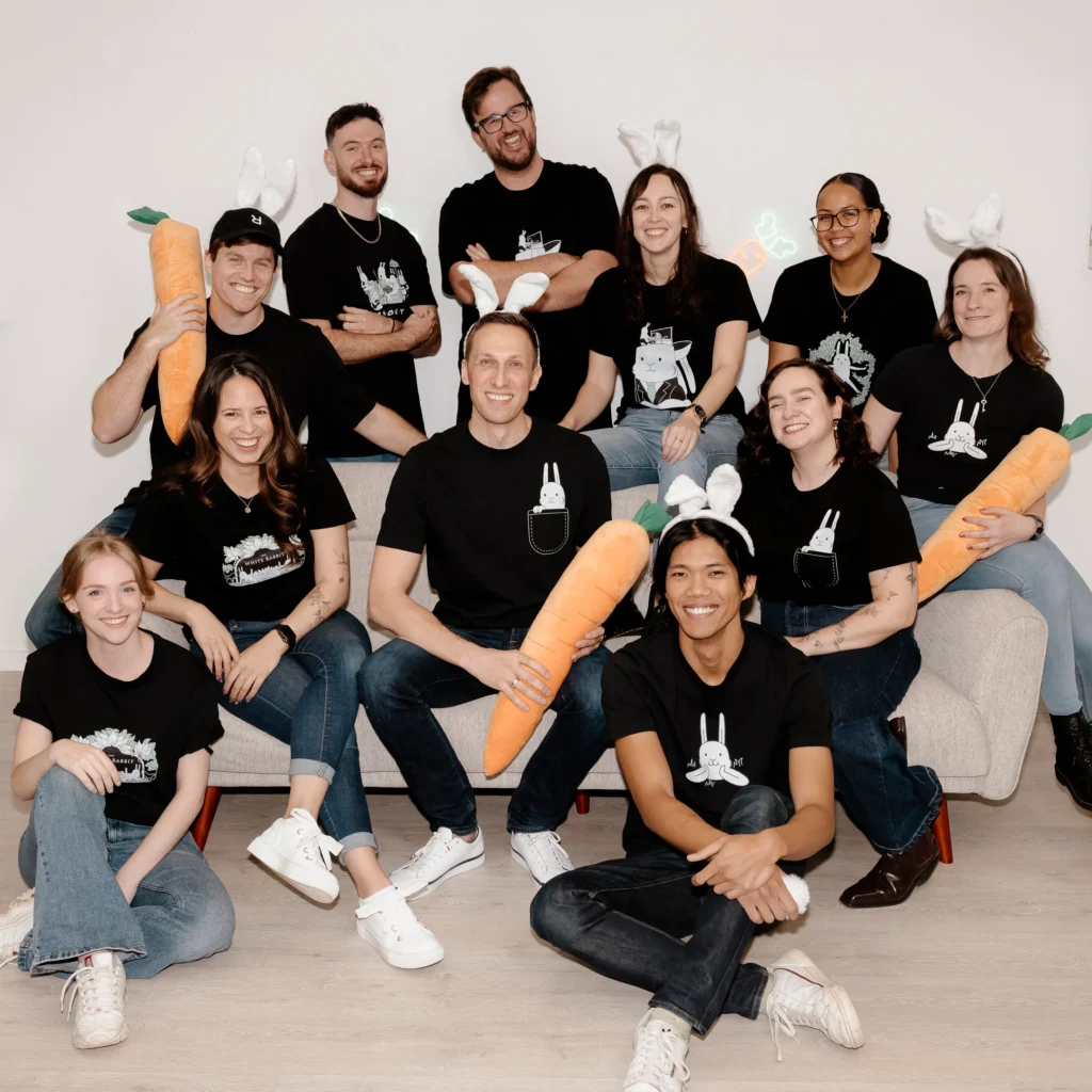 Group photo of white rabbit team in bunny ears with carrot props